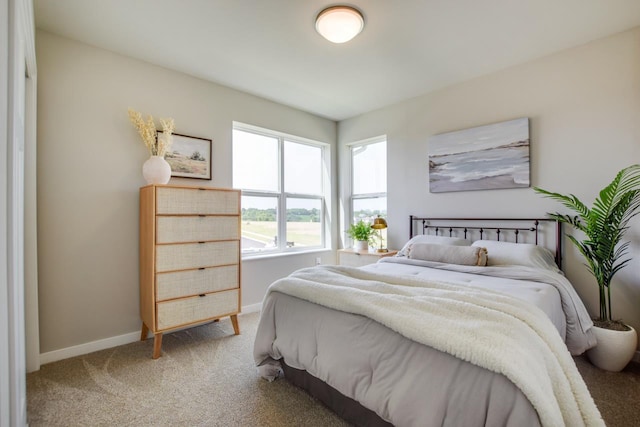 bedroom featuring light carpet and baseboards