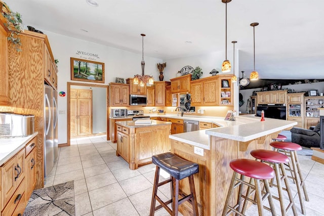 kitchen featuring light tile patterned floors, open floor plan, a kitchen breakfast bar, stainless steel appliances, and light countertops