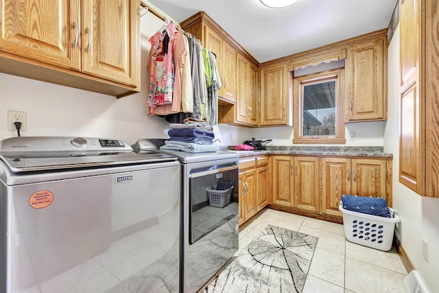 washroom featuring light tile patterned floors, visible vents, washing machine and clothes dryer, and cabinet space