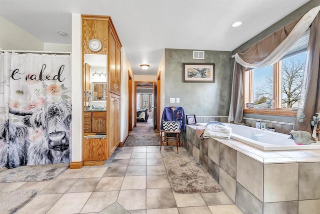 bathroom featuring visible vents, a shower with shower curtain, a garden tub, tile patterned flooring, and vanity