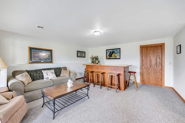 living room featuring a bar, baseboards, light carpet, and visible vents