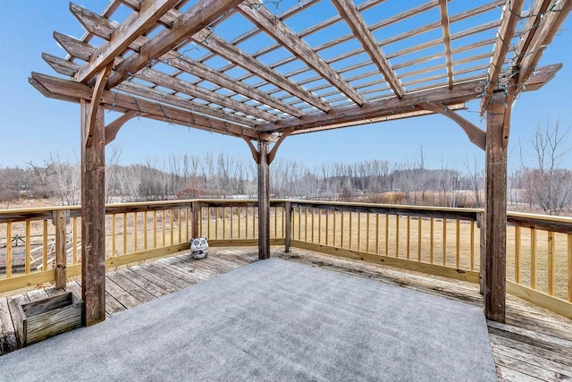 wooden terrace featuring a wooded view and a pergola