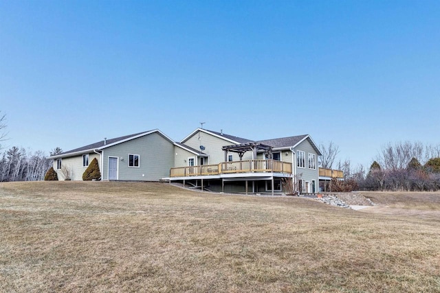 rear view of house featuring a yard, a wooden deck, and a pergola