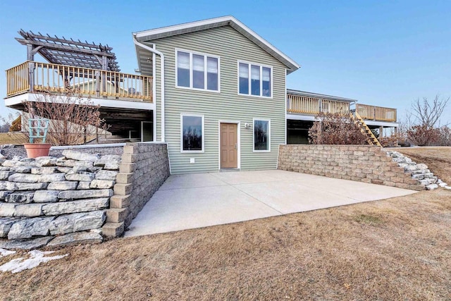 rear view of property with a deck, a patio area, stairway, and a pergola