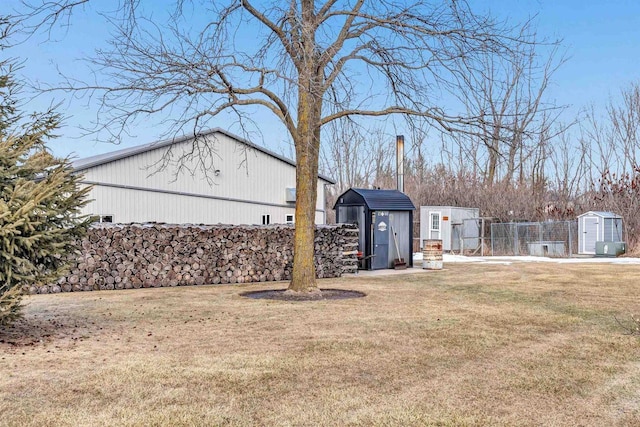 view of yard with a storage shed, fence, and an outbuilding