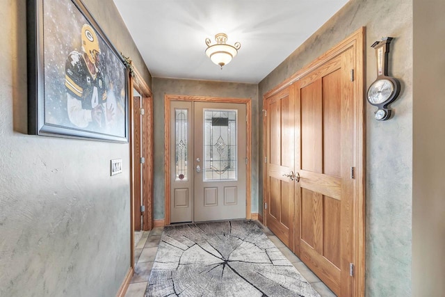 foyer featuring light tile patterned flooring and baseboards