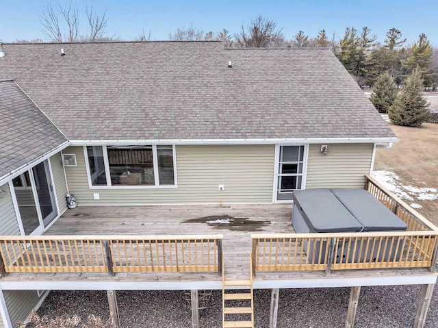 back of house featuring a wooden deck and roof with shingles