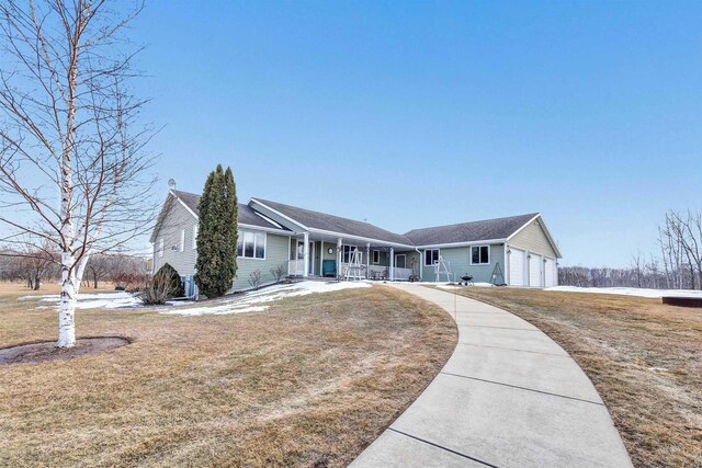 ranch-style house featuring a garage, a front lawn, and a porch