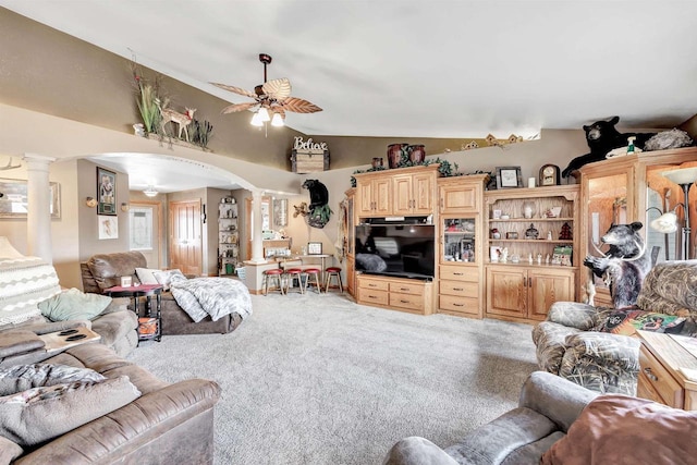 living area featuring arched walkways, carpet, lofted ceiling, and ornate columns