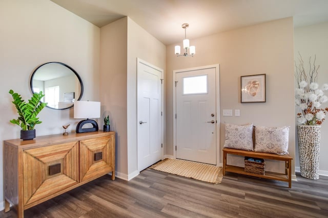 entrance foyer featuring dark wood-style floors, baseboards, and a chandelier