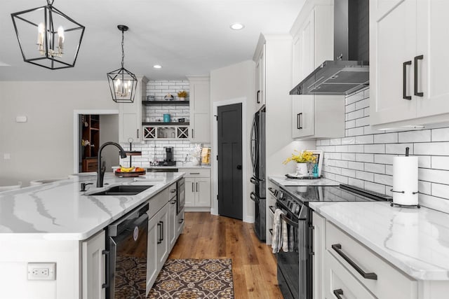 kitchen featuring white cabinets, wall chimney range hood, black appliances, open shelves, and a sink