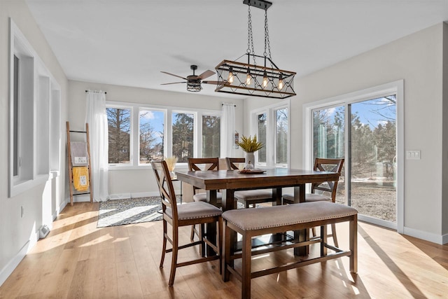 dining area featuring light wood-style flooring and baseboards