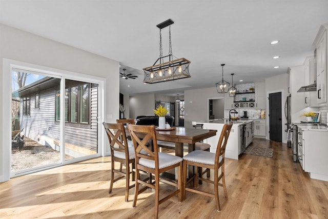 dining space featuring light wood finished floors, a ceiling fan, and recessed lighting