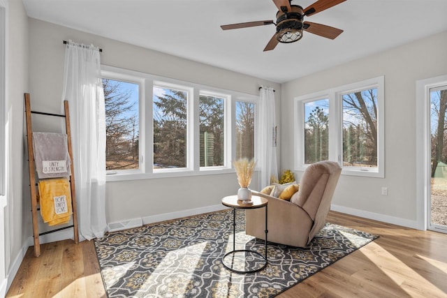 sitting room with a ceiling fan, baseboards, visible vents, and wood finished floors