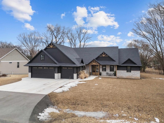 craftsman house featuring a shingled roof, stone siding, driveway, and an attached garage