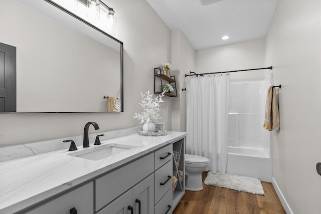 full bathroom with baseboards, toilet, wood finished floors, shower / bathtub combination with curtain, and vanity