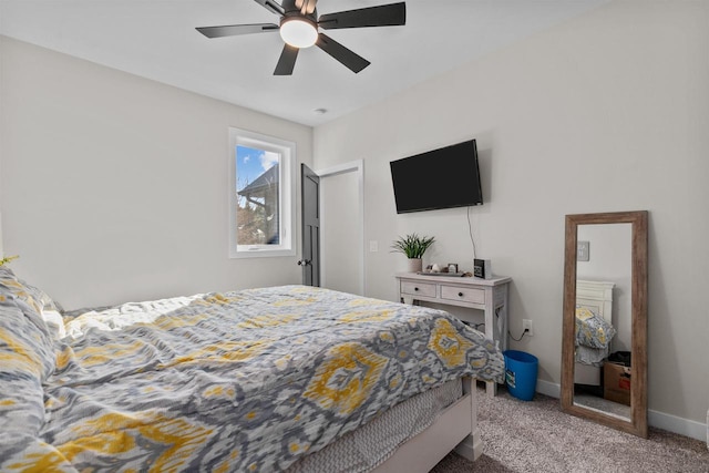 carpeted bedroom with ceiling fan and baseboards