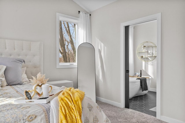 carpeted bedroom featuring lofted ceiling and baseboards