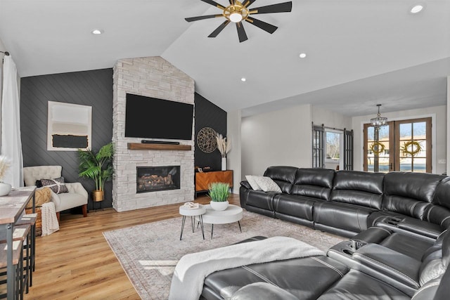 living area featuring ceiling fan, vaulted ceiling, light wood-type flooring, a fireplace, and recessed lighting