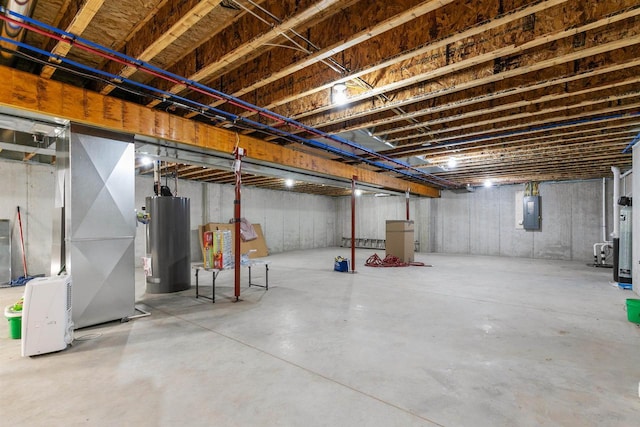 unfinished below grade area featuring gas water heater, electric panel, and heating unit