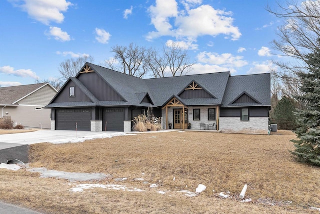 view of front facade with a garage, stone siding, driveway, roof with shingles, and board and batten siding