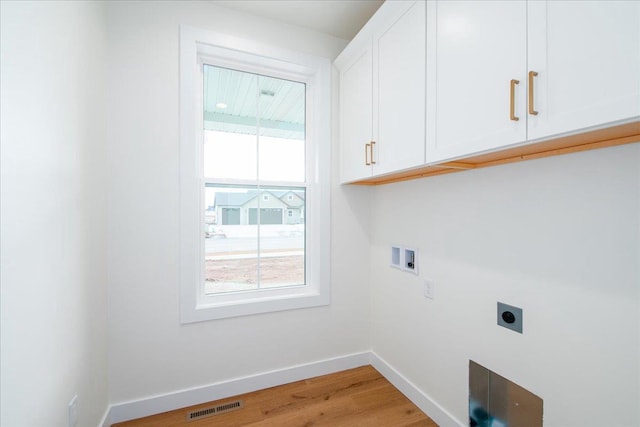 washroom with hookup for a washing machine, hookup for an electric dryer, visible vents, baseboards, and cabinet space