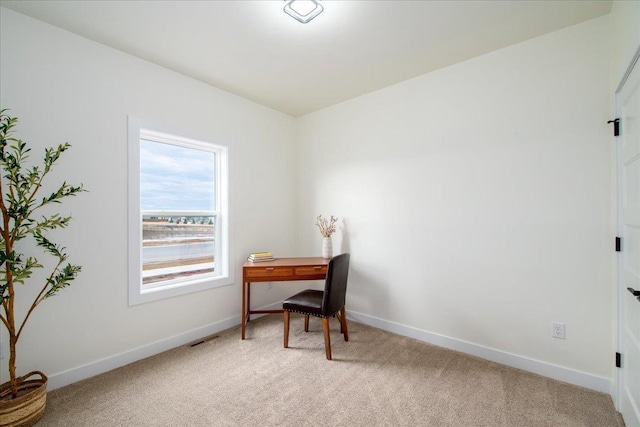 office space featuring light carpet, visible vents, and baseboards