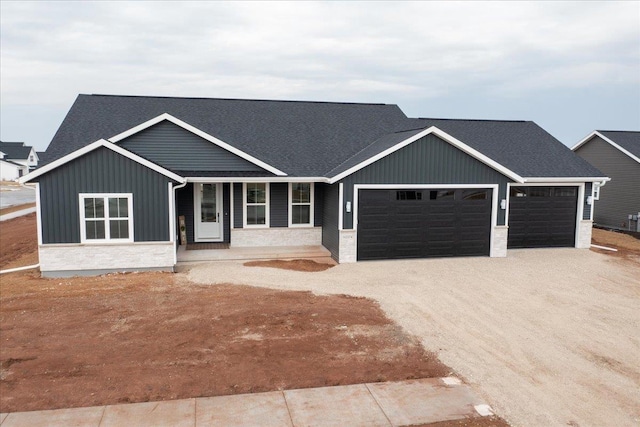 view of front of property featuring board and batten siding, driveway, and a garage