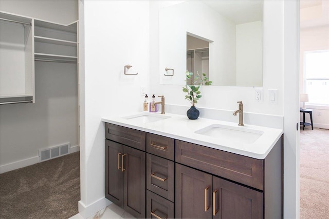 bathroom featuring visible vents, a sink, and baseboards