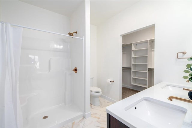 full bathroom with toilet, marble finish floor, a shower stall, and a sink