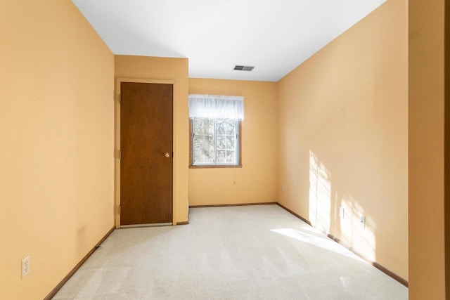 carpeted spare room featuring visible vents and baseboards