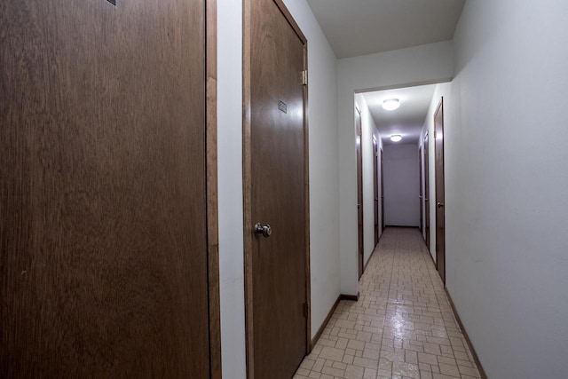 hall with brick floor and baseboards