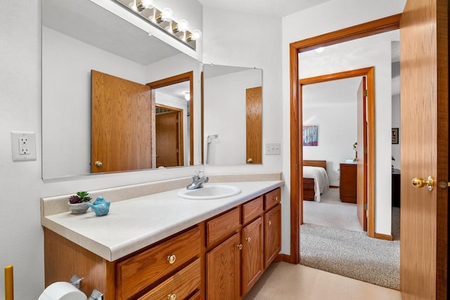 ensuite bathroom featuring vanity, ensuite bathroom, and baseboards