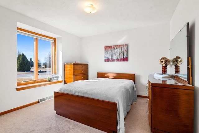 carpeted bedroom with visible vents and baseboards