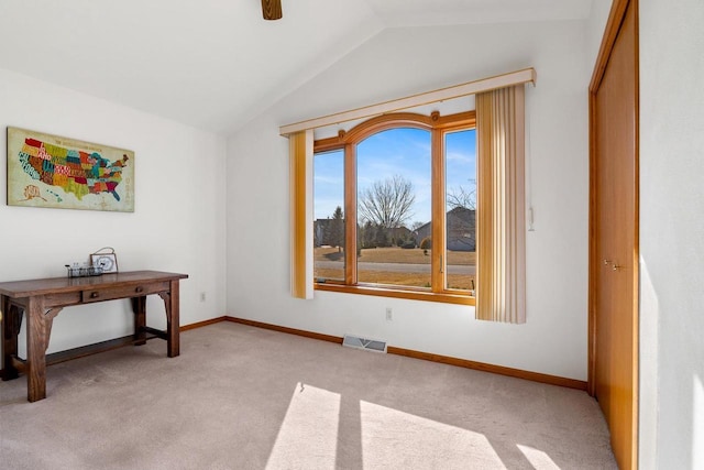 interior space with vaulted ceiling, light colored carpet, visible vents, and baseboards