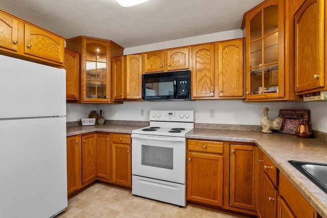 kitchen featuring brown cabinets, white appliances, and glass insert cabinets