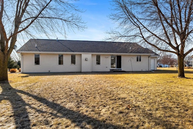 rear view of property with a yard and a shingled roof