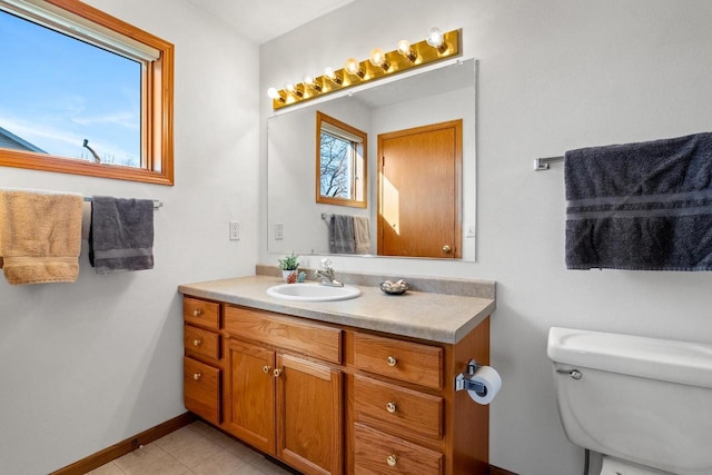 bathroom featuring tile patterned flooring, toilet, vanity, and baseboards