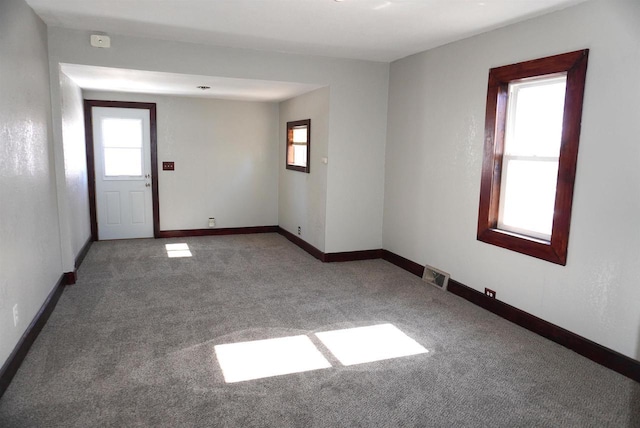 carpeted empty room with baseboards and visible vents