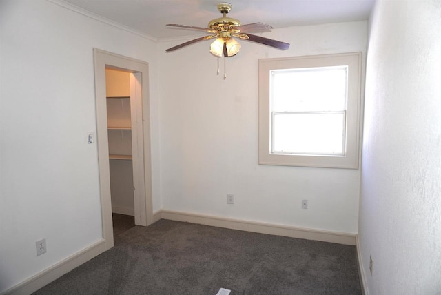 carpeted empty room with a ceiling fan and baseboards