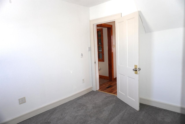 empty room featuring carpet and baseboards