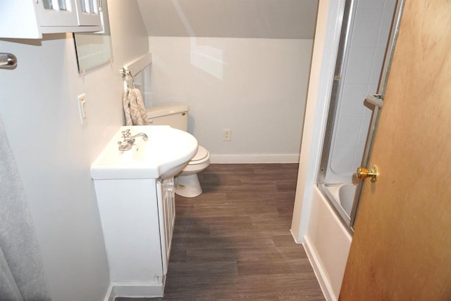 bathroom featuring shower / bath combination with glass door, toilet, vanity, wood finished floors, and baseboards