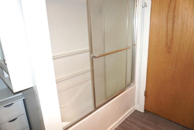 full bathroom with bath / shower combo with glass door and wood finished floors