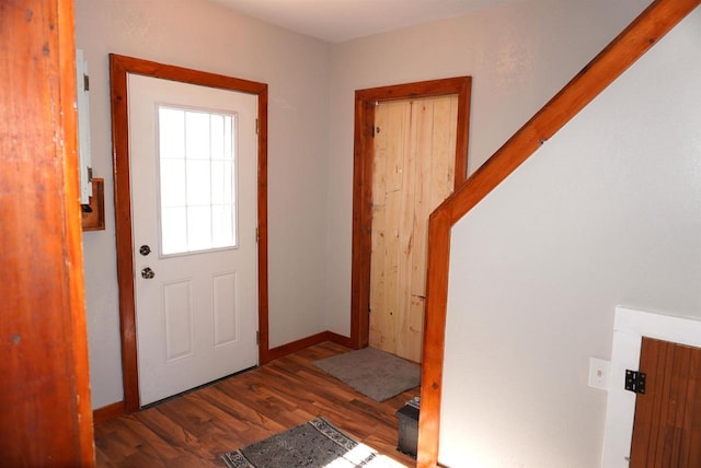 doorway featuring baseboards and wood finished floors