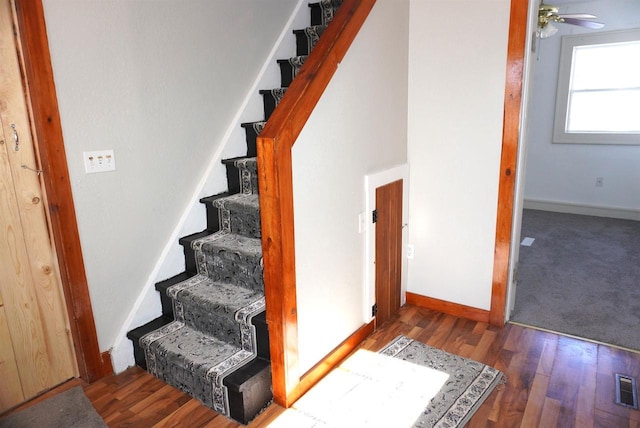 stairway with a ceiling fan, wood finished floors, visible vents, and baseboards