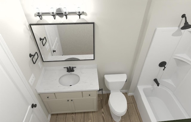 bathroom featuring baseboards, toilet, wood finished floors, vanity, and washtub / shower combination