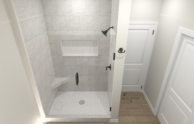 bathroom with a stall shower and baseboards