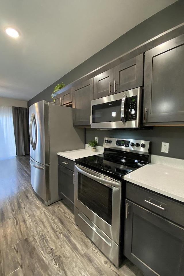 kitchen with appliances with stainless steel finishes, light countertops, and light wood-style flooring