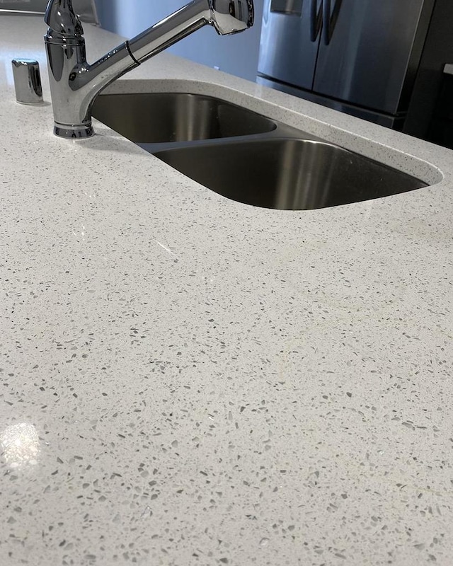 details featuring light stone counters and a sink