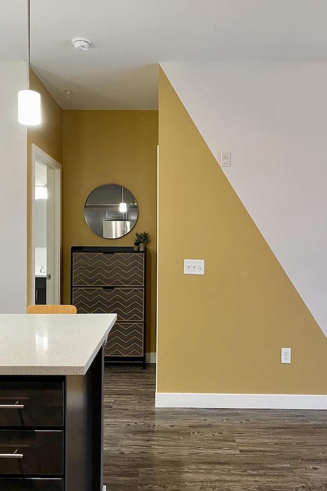 kitchen featuring dark wood-style floors, baseboards, light countertops, and decorative light fixtures